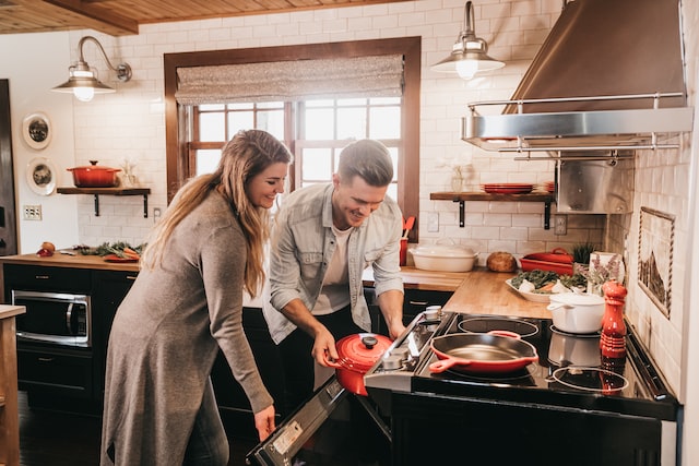 couple cooking food in the oven together