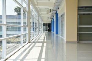 a long hallway with blue and white doors and windows